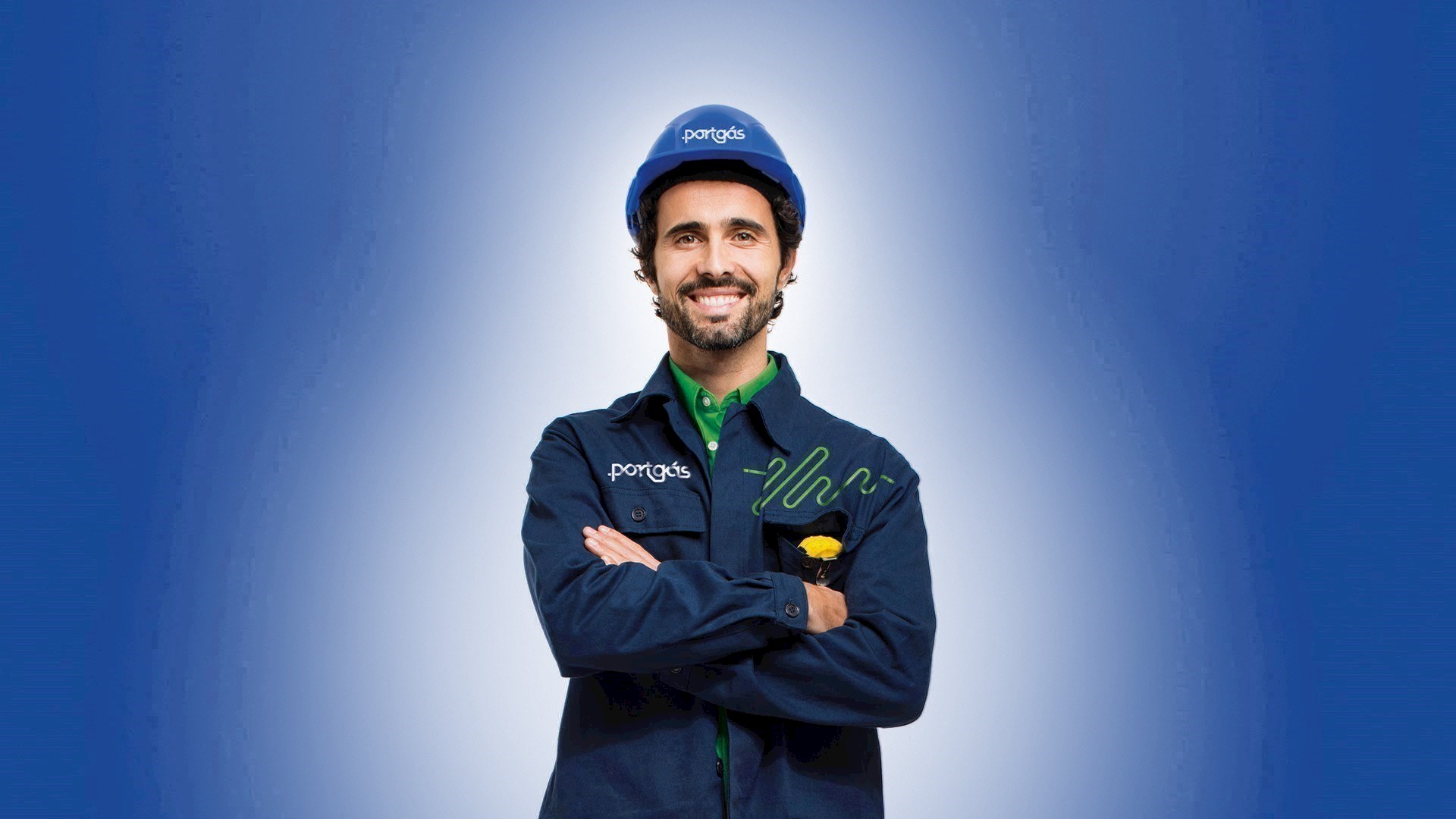 Homem com farda Portgás a sorrir de braços cruzados